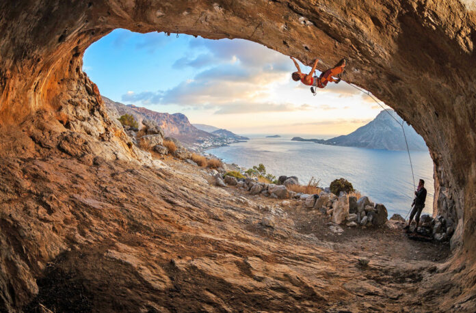 Young,Woman,Lead,Climbing,In,Cave,With,Beautiful,View,In