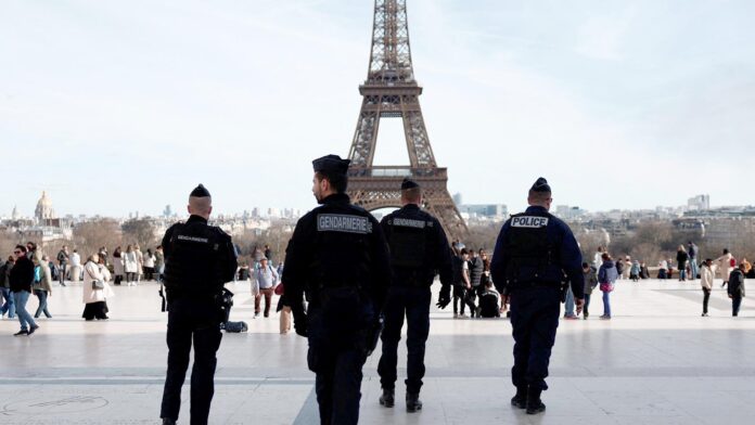 French police and gendarmes patrol near the Eiffel Tower in Paris