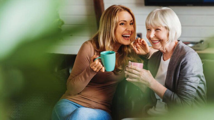 Happy,Senior,Mother,With,Adult,Daughter,Sitting,On,Couch,And